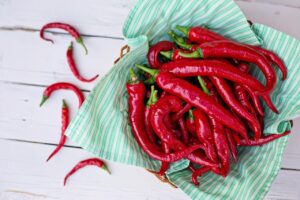 Peperoncino rosso su un piatto, simbolo di cibi piccanti e effetti sulla couperose.