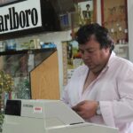 Immagine di un tabaccaio sorridente mentre mostra biglietti del Gratta e Vinci.