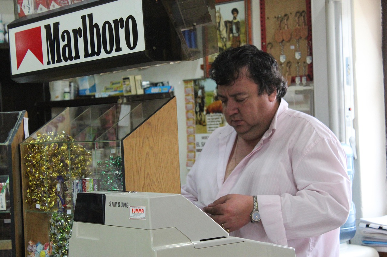 Immagine di un tabaccaio sorridente mentre mostra biglietti del Gratta e Vinci.