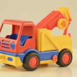 Giocattoli di plastica degli anni '80 con etichette originali su sfondo bianco, evidenziando il loro valore.