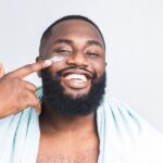 Uomo applica crema rassodante sul braccio, evidenziando effetti positivi sulla pelle.