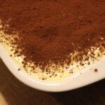 Montaggio dei tuorli per un tiramisù perfetto, con fruste e ciotola in evidenza.