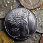 Due Lire con ulivo, moneta italiana, esposta su sfondo neutro per illustrare il loro valore nel mercato numismatico.